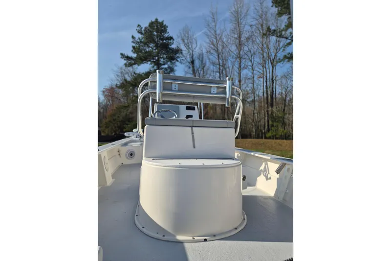 Slide: The Image of 2024 May-Craft 22 Hancock Skiff boat interior with console and seating, surrounded by trees. - 15