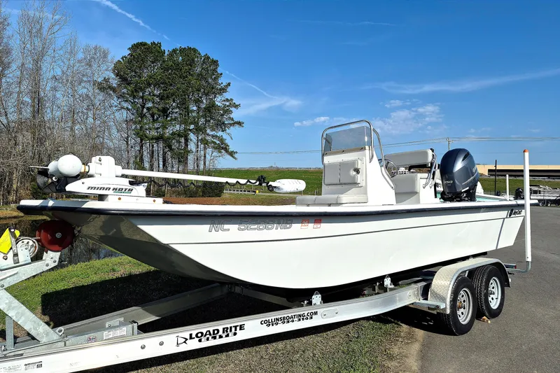 Slide: The Image of 2024 May-Craft 22 Hancock Skiff on trailer, parked outdoors under clear blue sky. - 2