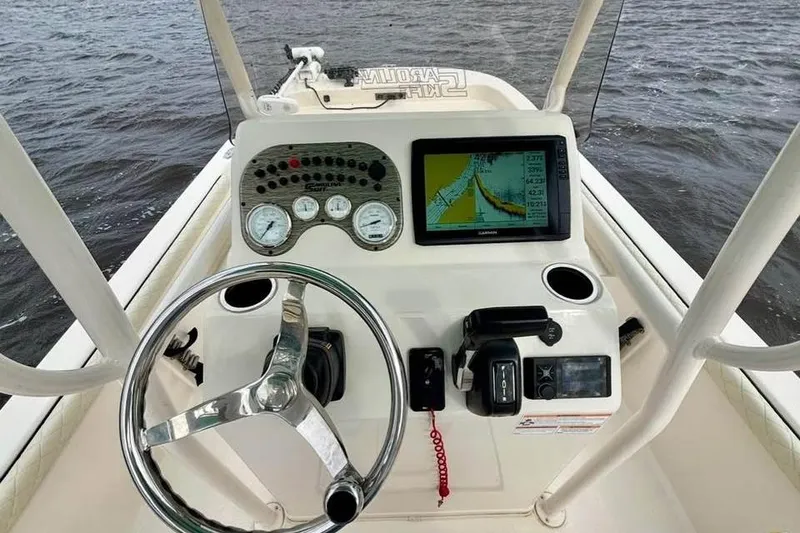 Slide: The Image of 2024 Carolina Skiff 23 LS boat dashboard with steering wheel and navigation display. - 6