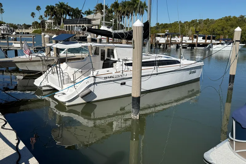The Image of 2014 Gemini Legacy 35 catamaran docked at a marina with palm trees in the background. - 0