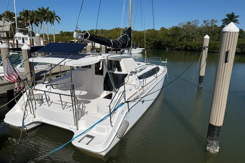 Slide: The Image of 2014 Gemini Legacy 35 catamaran docked in a marina with solar panels. - 2