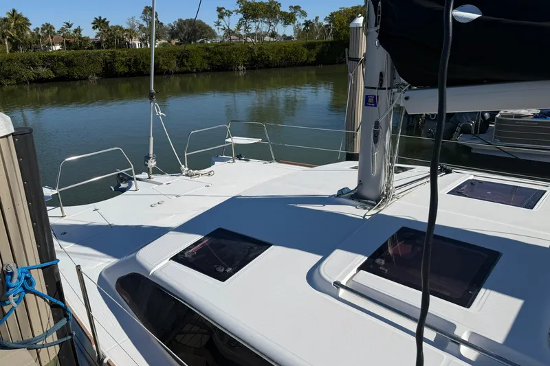 Slide: The Image of 2014 Gemini Legacy 35 catamaran docked by a serene waterway. - 4