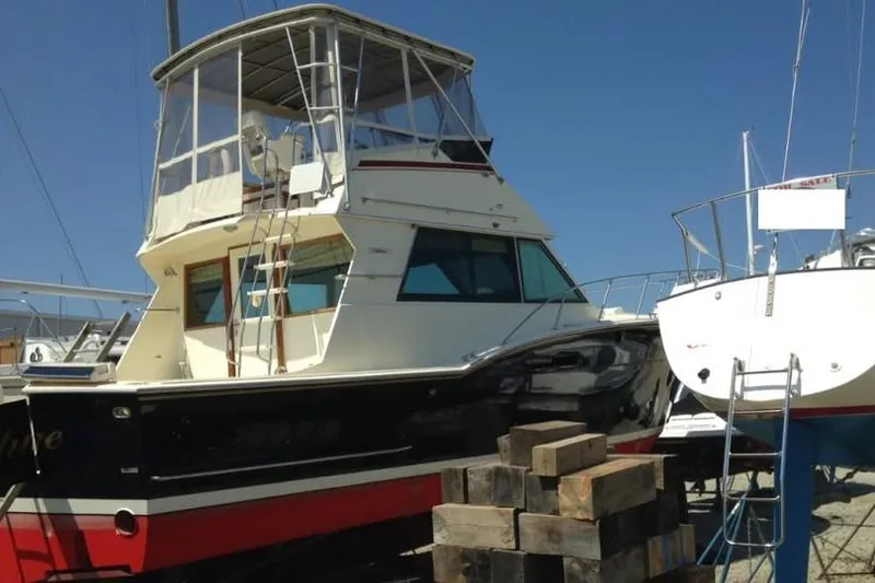 The Image of 1979 Hatteras 46 Convertible yacht on dry dock under clear blue sky. - 0