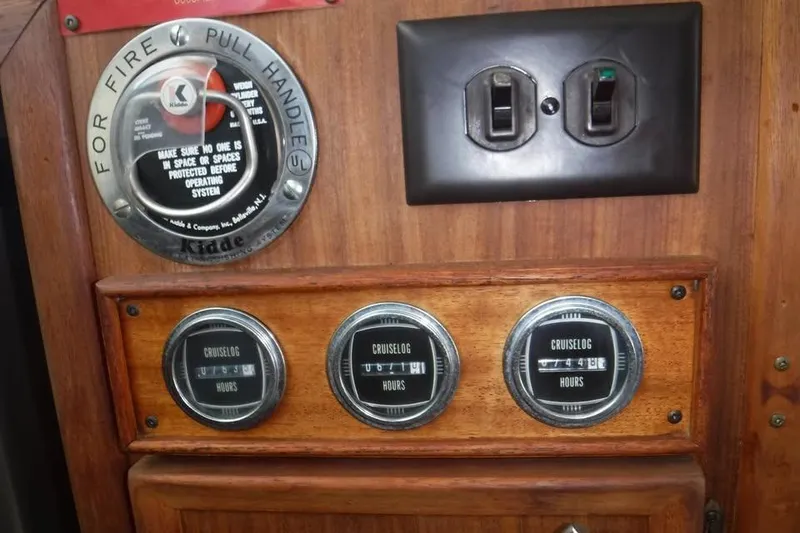 Slide: The Image of 1979 Hatteras 46 Convertible dashboard with fire safety handle and cruise log meters. - 10