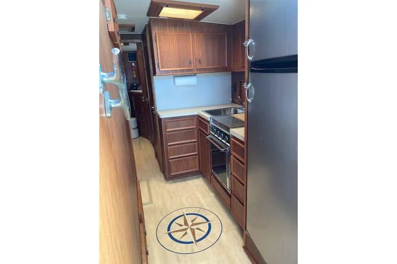 Slide: The Image of 1979 Hatteras 46 Convertible yacht kitchen with wood cabinets and stainless steel appliances. - 14
