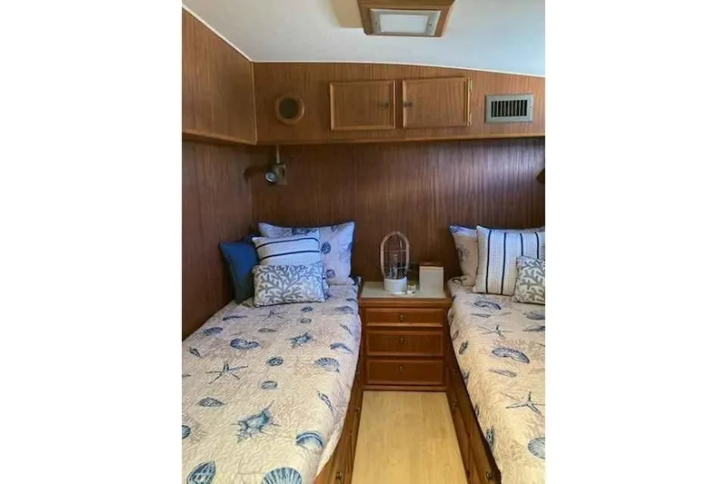 Slide: The Image of Twin beds in a 1979 Hatteras 46 Convertible cabin with nautical-themed bedding. - 15