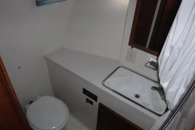 Slide: The Image of 1979 Hatteras 46 Convertible yacht bathroom with sink, toilet, and mirror. - 6