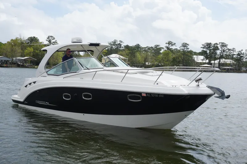 The Image of 2014 Chaparral 330 Signature boat cruising on a calm lake with trees in the background. - 1