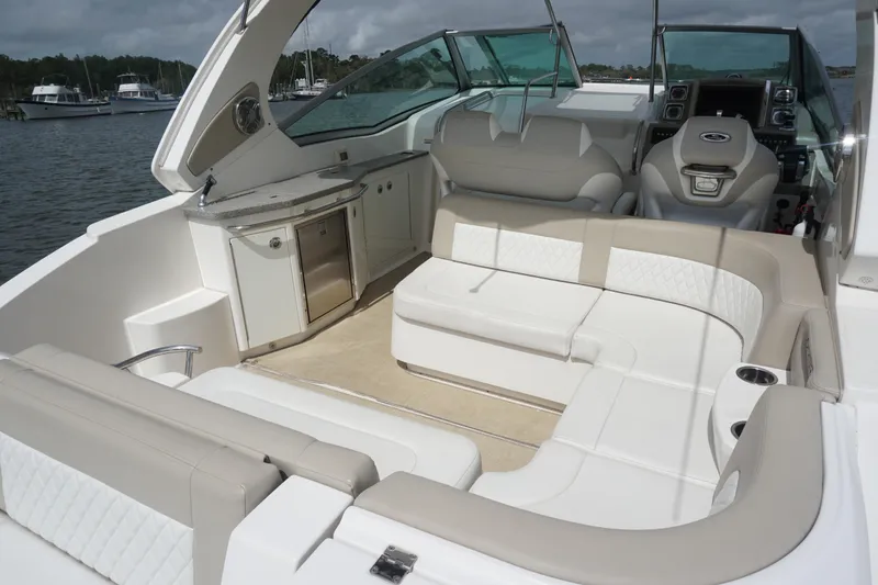 Slide: The Image of 2014 Chaparral 330 Signature boat interior with seating and helm, docked by the water. - 13