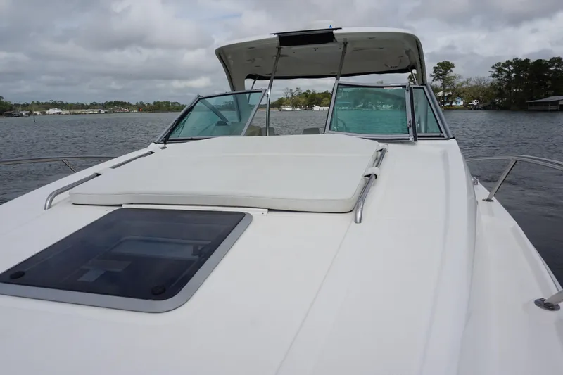 Slide: The Image of 2014 Chaparral 330 Signature boat on calm water, featuring a spacious deck and windshield. - 16