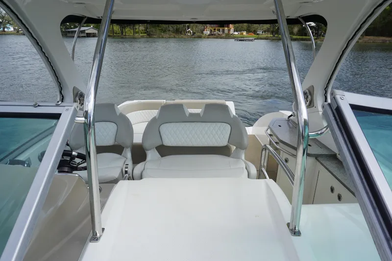 Slide: The Image of 2014 Chaparral 330 Signature boat interior with seating, overlooking a serene lake. - 18