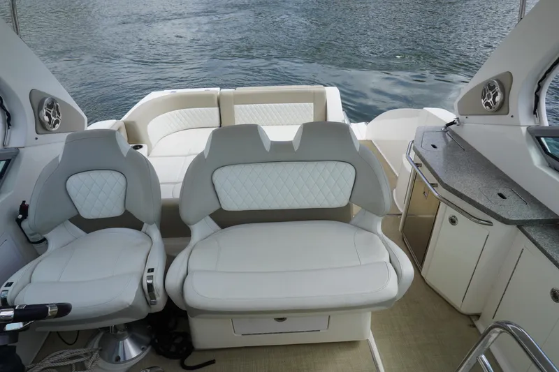 Slide: The Image of 2014 Chaparral 330 Signature boat interior with white seating and kitchenette. - 19