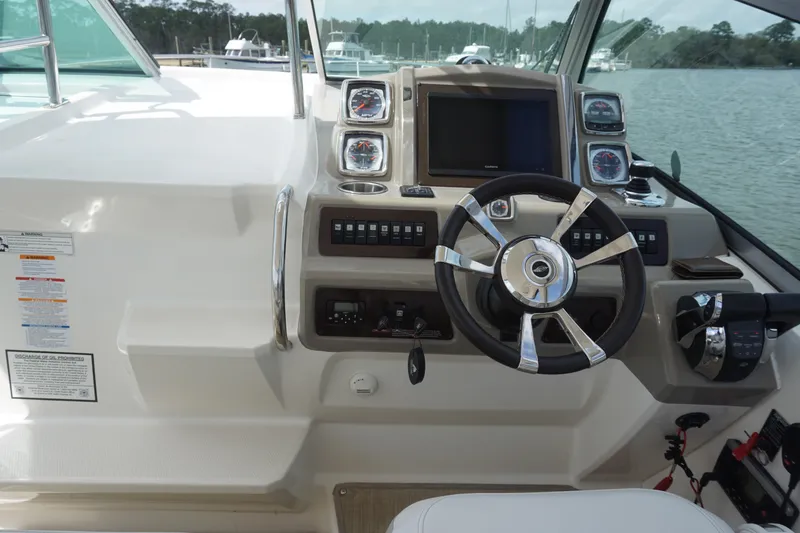Slide: The Image of 2014 Chaparral 330 Signature boat helm with steering wheel and control panel. - 21