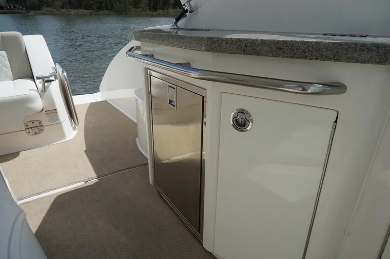 Slide: The Image of 2014 Chaparral 330 Signature yacht interior with sleek kitchenette and seating area. - 23