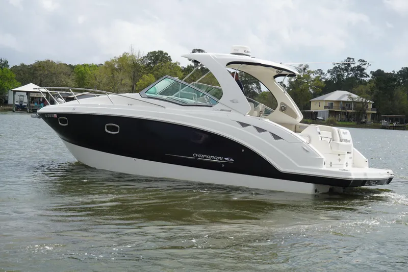 Slide: The Image of 2014 Chaparral 330 Signature boat cruising on a calm lake. - 3