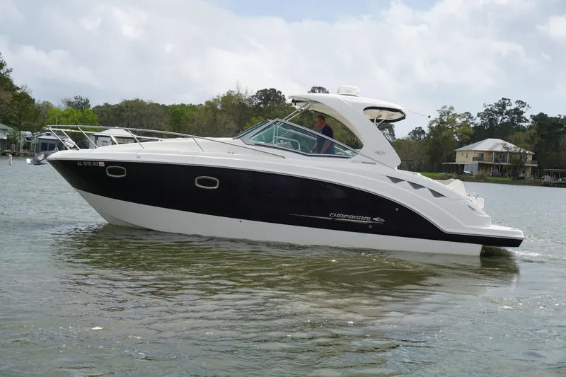 Slide: The Image of 2014 Chaparral 330 Signature boat cruising on a calm lake. - 4