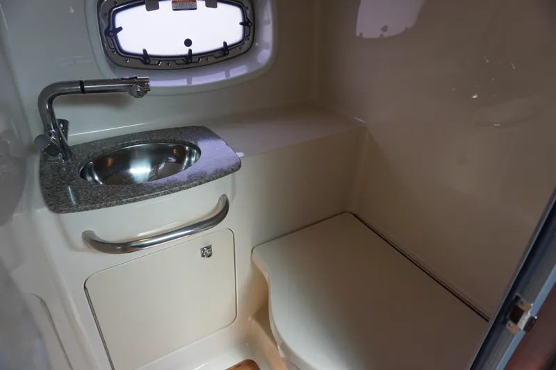 Slide: The Image of 2014 Chaparral 330 Signature boat bathroom with sink and porthole window. - 40