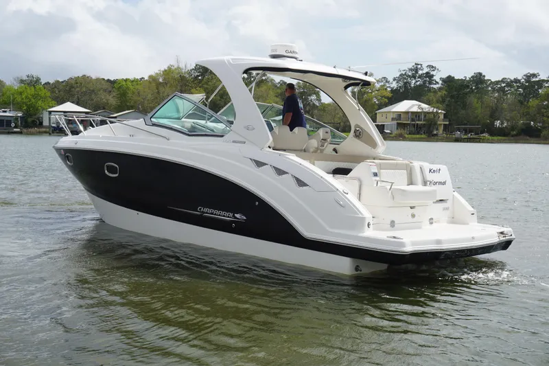 Slide: The Image of 2014 Chaparral 330 Signature boat cruising on a calm lake with scenic background. - 8