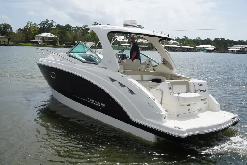 Slide: The Image of 2014 Chaparral 330 Signature boat cruising on a calm lake with scenic background. - 9