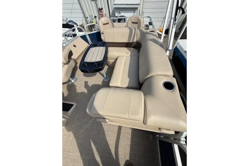 Slide: The Image of 2019 Sun Tracker SportFish 22 DLX boat interior with beige seating and table. - 11