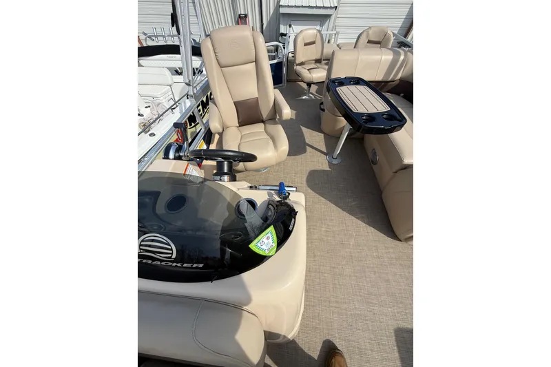 Slide: The Image of 2019 Sun Tracker SportFish 22 DLX interior with beige seating and steering console. - 12