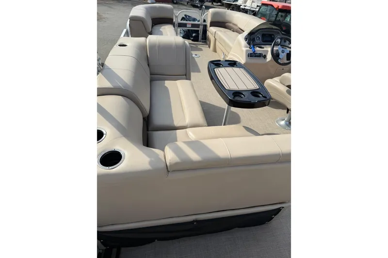 Slide: The Image of 2019 Sun Tracker SportFish 22 DLX pontoon boat interior with beige seating and table. - 16