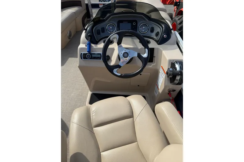 Slide: The Image of 2019 Sun Tracker SportFish 22 DLX boat dashboard with steering wheel and beige seating. - 18