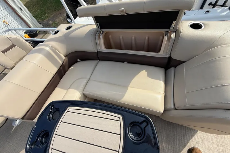 Slide: The Image of 2019 Sun Tracker SportFish 22 DLX boat interior with beige seating and storage compartment. - 25
