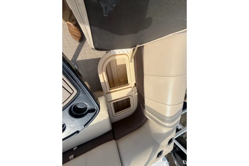 Slide: The Image of 2019 Sun Tracker SportFish 22 DLX boat interior with beige seating and storage compartment. - 28