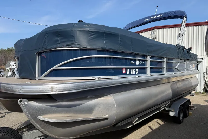 Slide: The Image of 2019 Sun Tracker SportFish 22 DLX pontoon boat on trailer, covered and parked outdoors. - 6