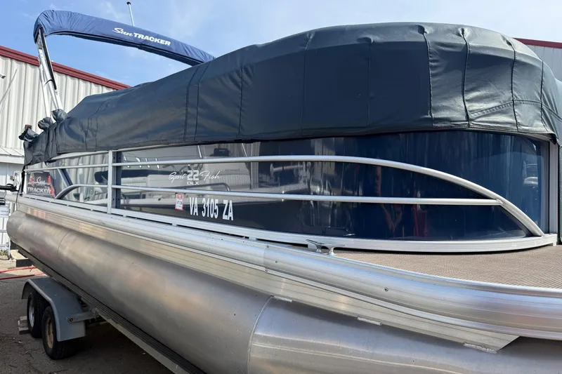 Slide: The Image of 2019 Sun Tracker SportFish 22 DLX pontoon boat with cover, parked on trailer. - 7