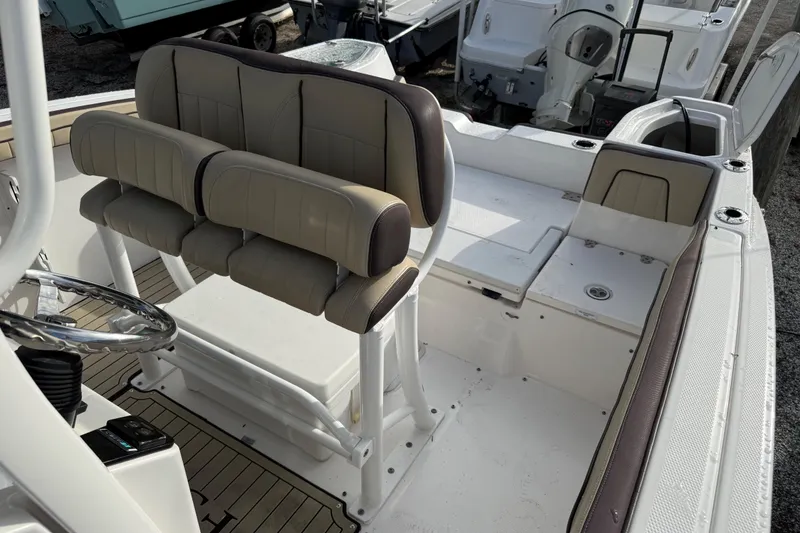Slide: The Image of 2021 Yamaha Boats 255 FSH Sport E interior with cushioned seating and steering wheel. - 10