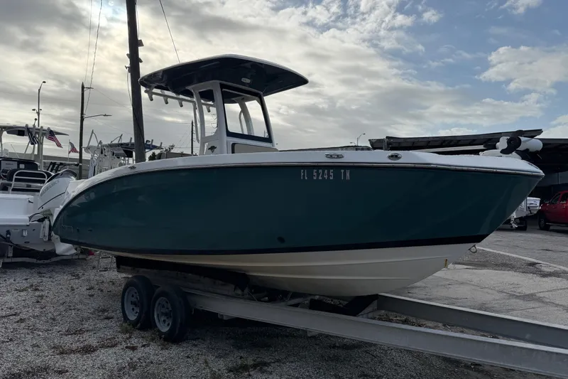 Slide: The Image of 2021 Yamaha Boats 255 FSH Sport E on trailer, parked outdoors under cloudy sky. - 3