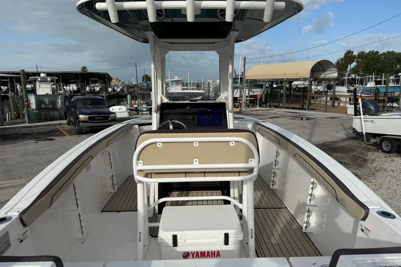 Slide: The Image of 2021 Yamaha Boats 255 FSH Sport E at a marina, showcasing helm and seating area. - 5