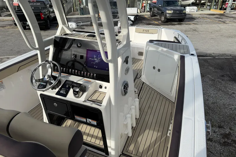 Slide: The Image of 2021 Yamaha Boats 255 FSH Sport E interior with steering console and seating. - 7