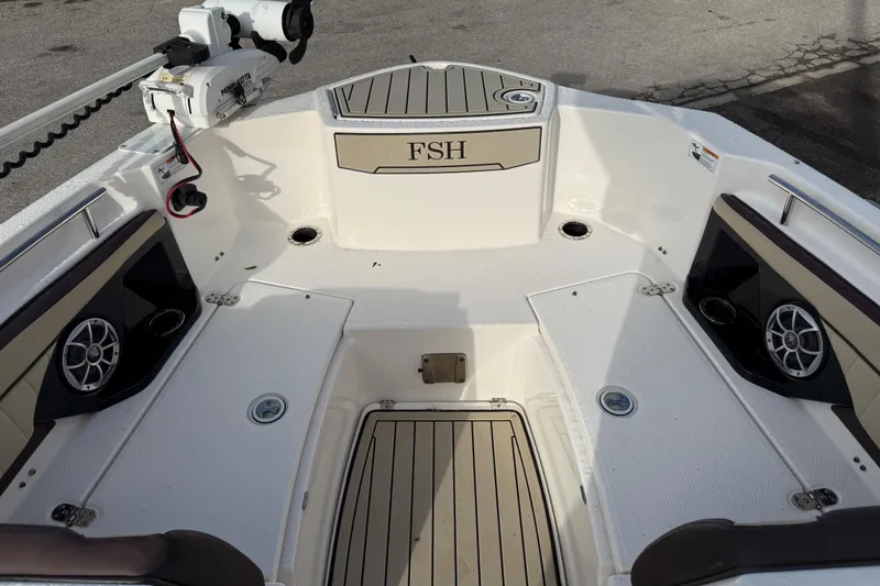 Slide: The Image of 2021 Yamaha Boats 255 FSH Sport E interior with speakers and fishing equipment. - 9