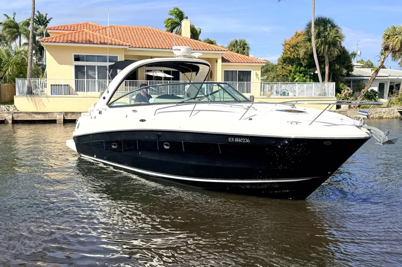 The Image of 2013 Sea Ray 370 Venture yacht on calm water near villa. - 0