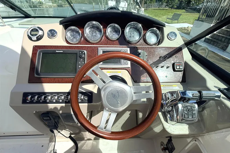 Slide: The Image of 2013 Sea Ray 370 Venture boat interior with beige seating and water view. - 10