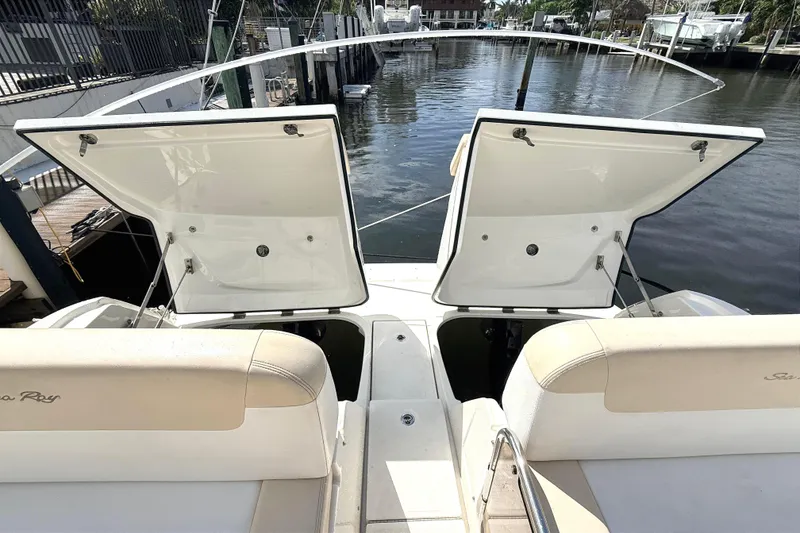 Slide: The Image of 2013 Sea Ray 370 Venture boat with open storage compartments, docked by the water. - 24