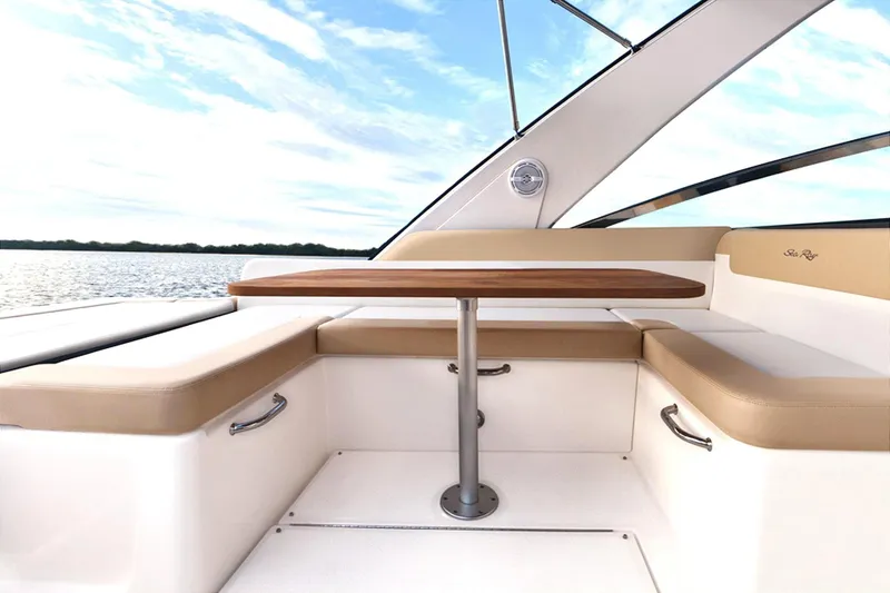 Slide: The Image of 2013 Sea Ray 370 Venture boat interior with wooden table and cushioned seating. - 6