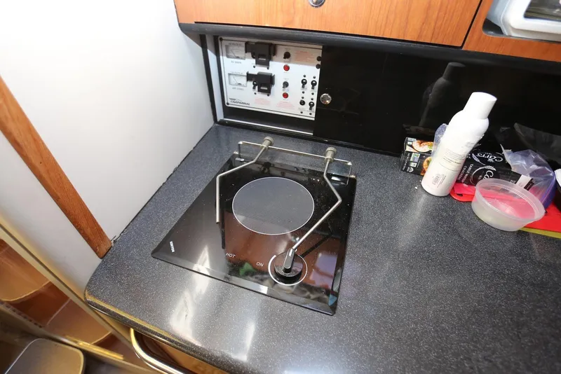 Slide: The Image of Compact kitchen area in a 2000 Chaparral Signature 300 boat with stove and control panel. - 27