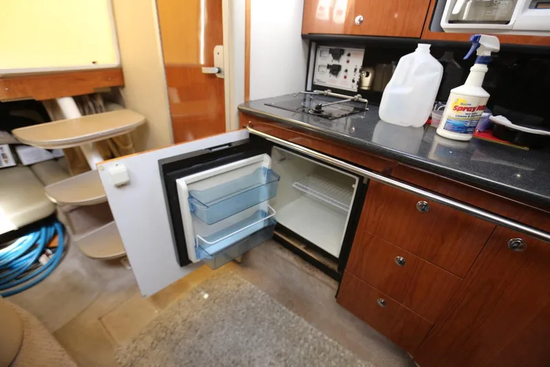 Slide: The Image of 2000 Chaparral Signature 300 boat interior with open mini fridge and kitchenette. - 32