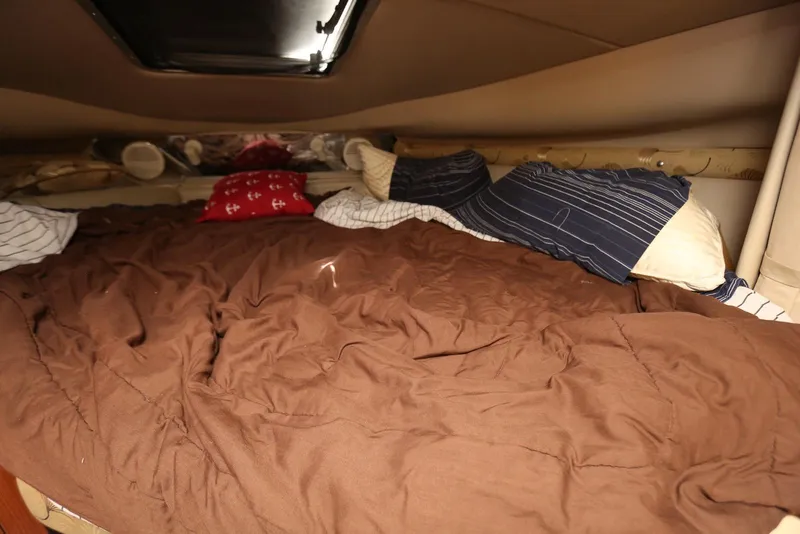 Slide: The Image of Cozy cabin bed inside a 2000 Chaparral Signature 300 boat, with pillows and brown bedding. - 36