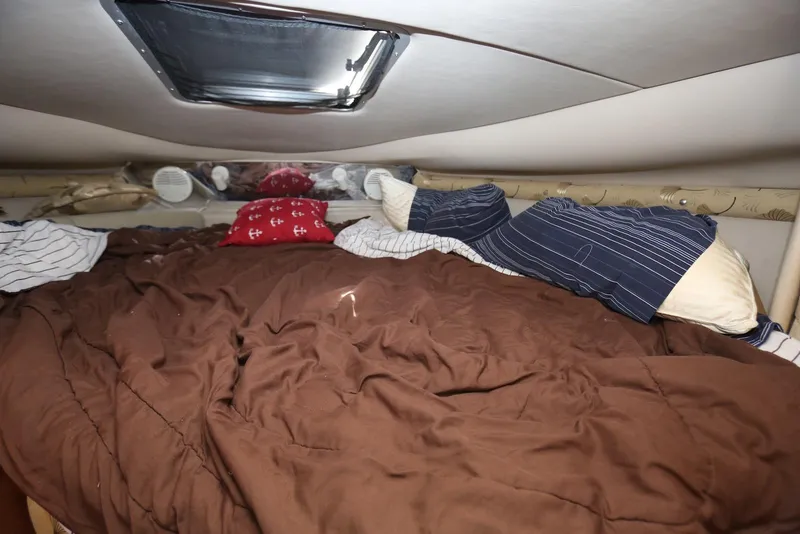 Slide: The Image of Cozy cabin bed inside 2000 Chaparral Signature 300 boat with pillows and brown comforter. - 37