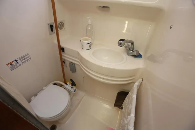 Slide: The Image of Compact bathroom in 2000 Chaparral Signature 300 boat, featuring toilet and sink. - 41