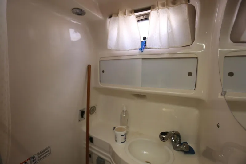 Slide: The Image of Interior of 2000 Chaparral Signature 300 boat bathroom with sink and storage. - 42