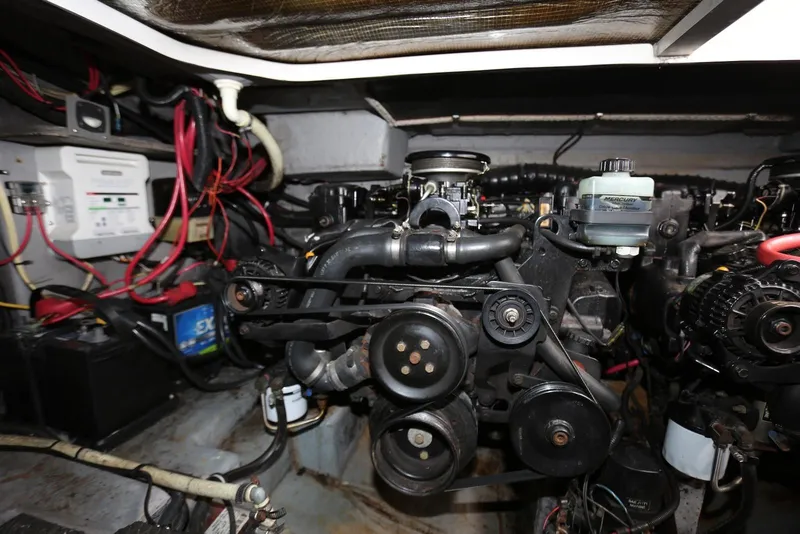 Slide: The Image of Engine compartment of a 2000 Chaparral Signature 300 boat, showcasing mechanical components and wiring. - 46