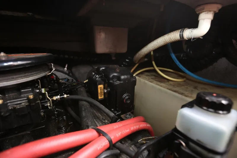 Slide: The Image of Engine compartment of a 2000 Chaparral Signature 300 boat, featuring hoses and components. - 49