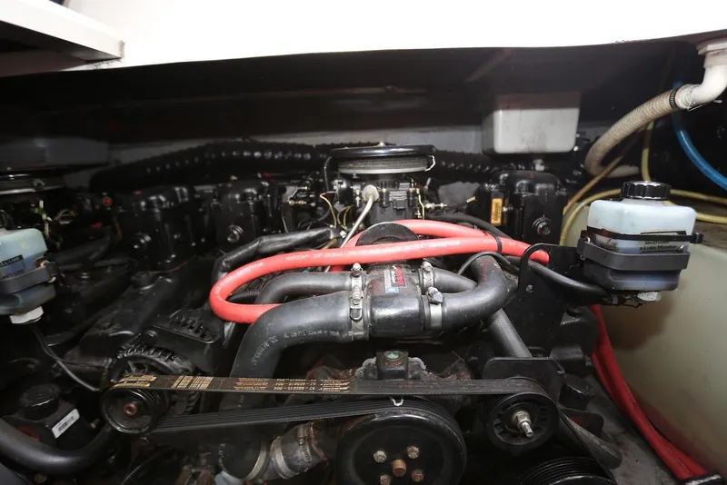 Slide: The Image of Engine compartment of a 2000 Chaparral Signature 300 boat, featuring hoses and components. - 55