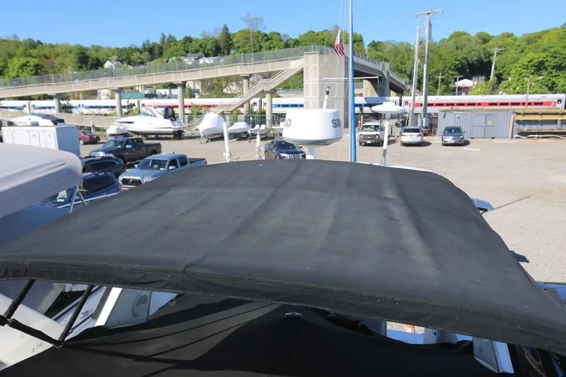 Slide: The Image of 2000 Chaparral Signature 300 boat with black canopy in a marina parking area. - 65